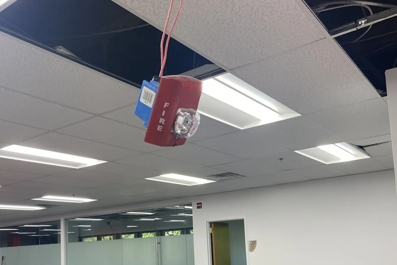 Horn strobe hanging from the ceiling during a commercial office renovation